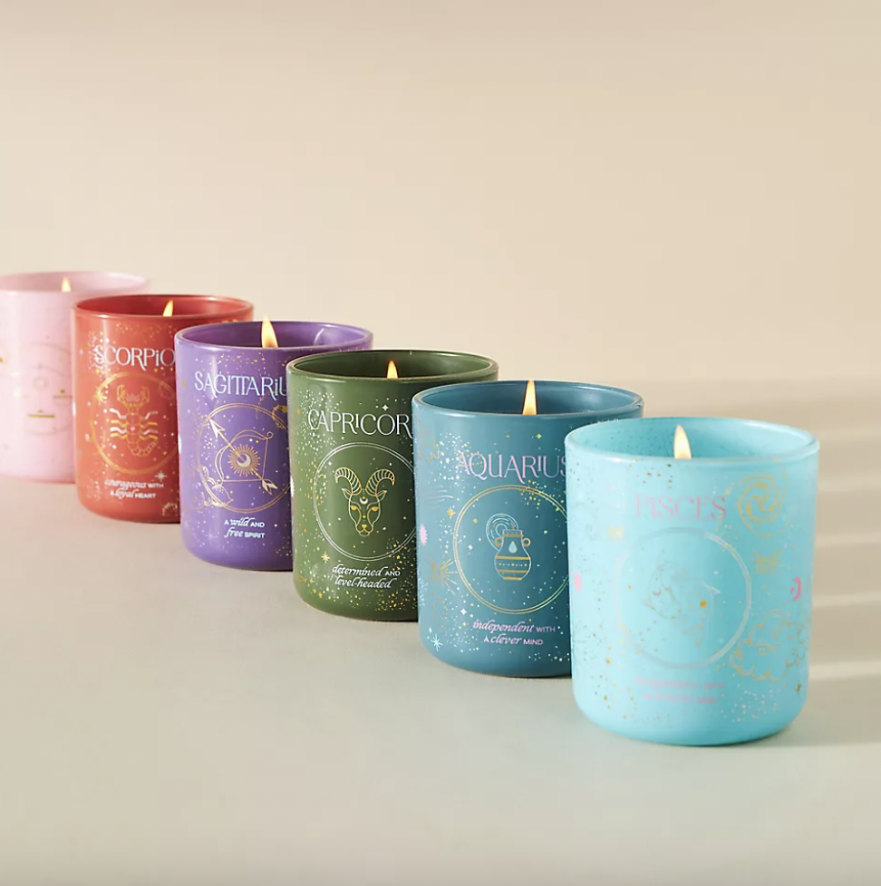 Five scented candles with Zodiac signs are arranged, labeled Scorpio, Sagittarius, Capricorn, Aquarius, and Pisces.