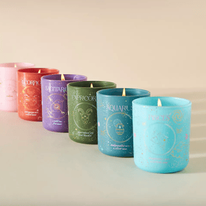 Five scented candles with Zodiac signs are arranged, labeled Scorpio, Sagittarius, Capricorn, Aquarius, and Pisces.