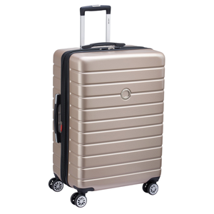 A gold-colored, hard-shell suitcase with a telescopic handle and four double-spinner wheels for easy mobility.