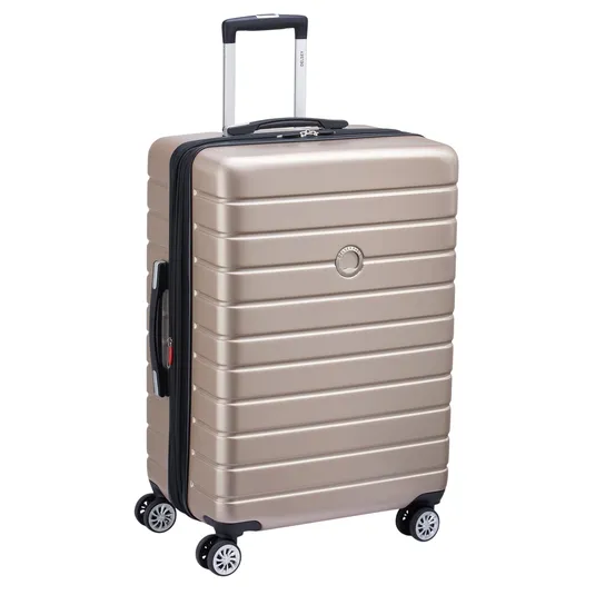 A gold-colored, hard-shell suitcase with a telescopic handle and four double-spinner wheels for easy mobility.