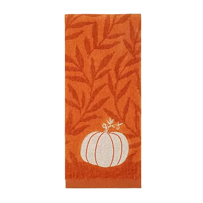 An orange hand towel featuring a pattern of leaves with a white embroidered pumpkin and swirling vine accents.