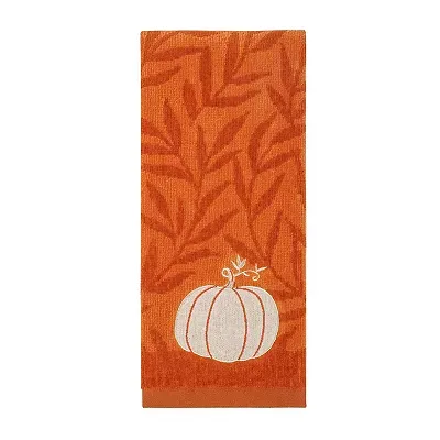 An orange hand towel featuring a pattern of leaves with a white embroidered pumpkin and swirling vine accents.