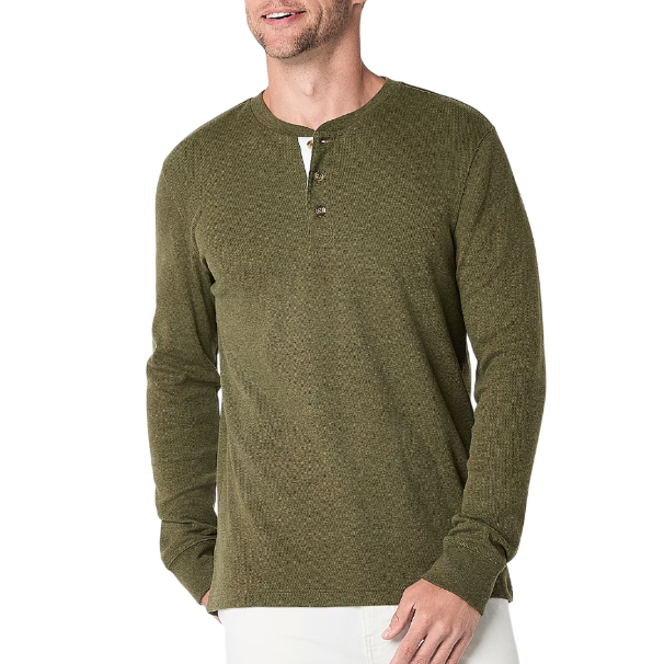 A man is wearing an olive green long-sleeve henley shirt with a three-button placket, paired with white pants.