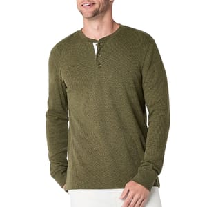 A man is wearing an olive green long-sleeve henley shirt with a three-button placket, paired with white pants.