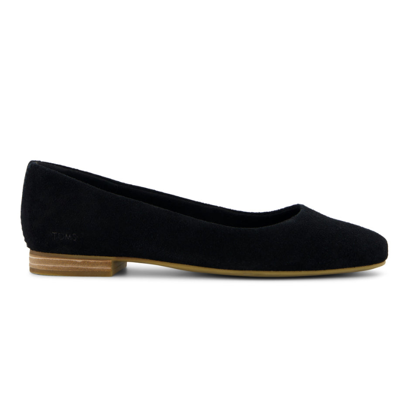 A black ballet flat with a low wooden heel, featuring a suede finish and the TOMS logo on the side.