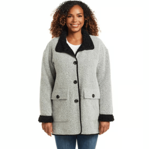 A woman is wearing a gray herringbone coat with black accents on the collar and cuffs. The coat features black buttons and flap pockets.