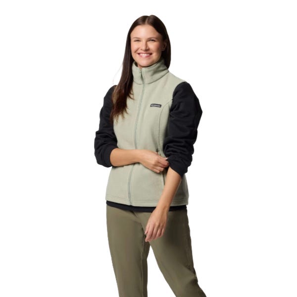 A woman is wearing a two-tone fleece jacket with a high collar and zip closure, paired with khaki pants.