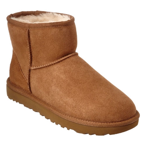 Tan ankle-high shearling boot with a plush inner lining and a flat, textured sole.