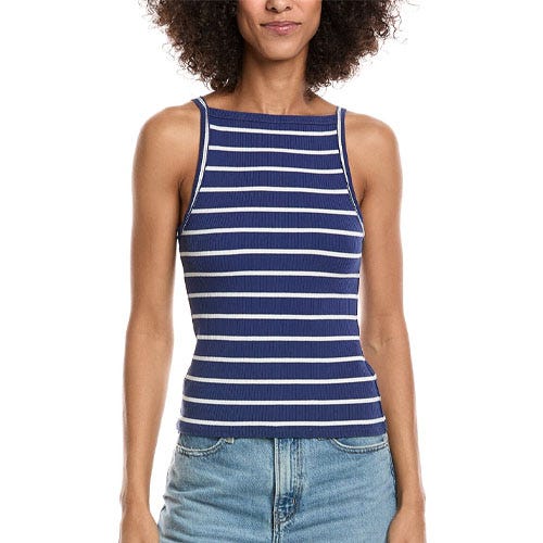 A woman wears a sleeveless navy and white striped ribbed tank top paired with light blue denim jeans.