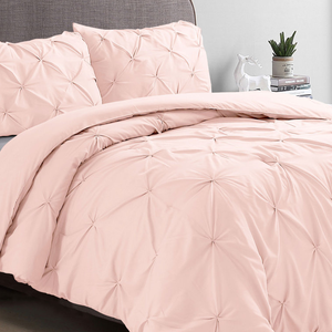 A king-size pintuck blush comforter set featuring an elegant gathered design, including a comforter and matching pillow shams. The bedding is soft pink and adds a touch of elegance and comfort to any bedroom decor.