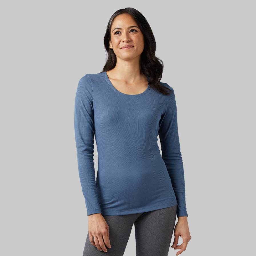 A woman is wearing a long-sleeved blue top and grey leggings.