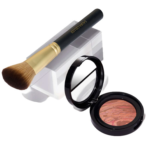 A makeup brush with a gold handle labeled \“Laura Geller\“ and a compact with marbled blush.