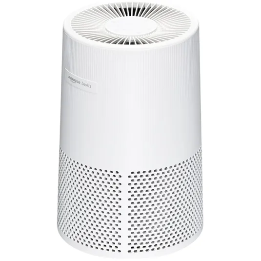 Amazon Basics air purifier in a white cylindrical design with a vented top and perforated sides.