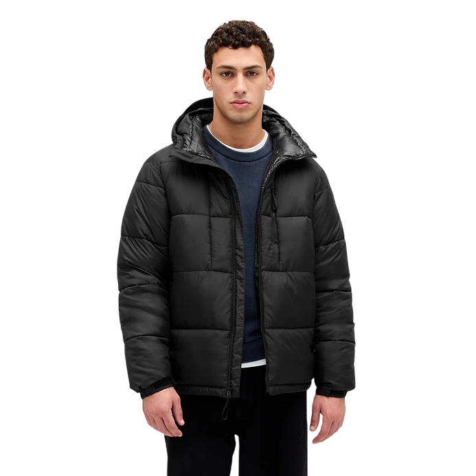 A man is wearing a black, quilted puffer jacket with a hood, over a dark blue sweatshirt.