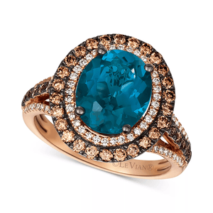A Le Vian ring featuring a large oval blue gemstone, surrounded by layers of brown and white diamonds, set in rose gold with a split shank band.