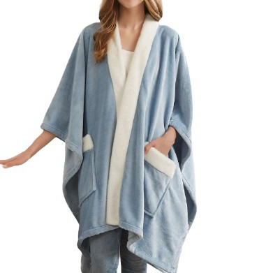A person is wearing a soft, blue fleece poncho with white trim and large front pockets, layered over casual clothing.