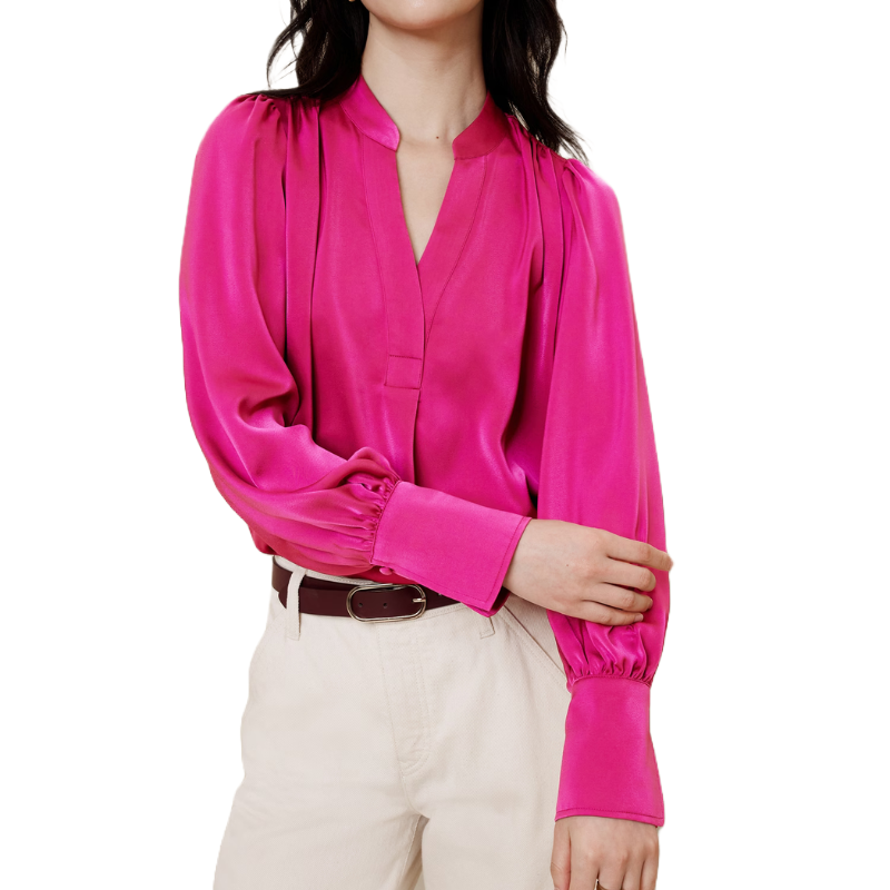 A vibrant pink crepe blouse with a deep V-neck, featuring voluminous long sleeves with gathered cuffs, paired with beige high-waisted trousers and a brown belt.
