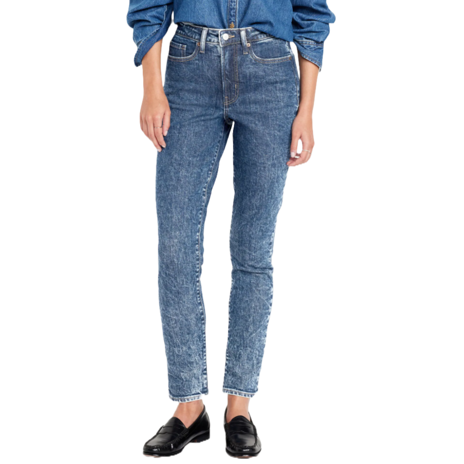 High-waisted, ankle-length skinny jeans with a medium wash and subtle distressed texture. Paired with black loafers and a matching denim shirt.