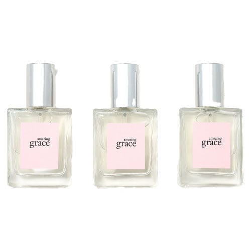 Three bottles of Amazing Grace perfume with a light pink label and silver cap.