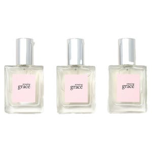 Three bottles of Amazing Grace perfume with a light pink label and silver cap.
