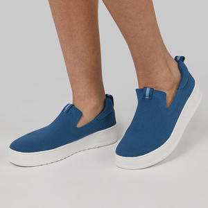 Blue slip-on sneakers with white soles.