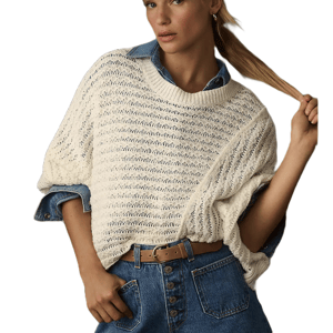 A person is wearing a cream-colored knit sweater over a blue denim shirt, paired with high-waisted blue jeans and a tan belt.