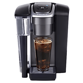 A single-serve coffee maker dispensing iced coffee into a tall glass, featuring a removable water reservoir and a sleek black design.