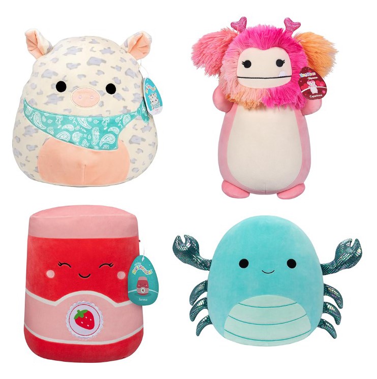 Four plush toys: a cow with a paisley bandana, a pink creature with heart antennae, a strawberry-themed cylinder, and a blue octopus.