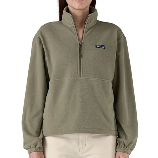 A light olive-green fleece quarter-zip pullover with a Patagonia logo on the left chest, paired with light beige pants.