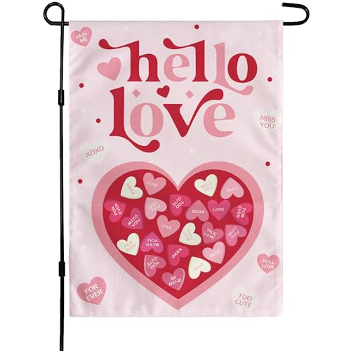 A garden flag with \“hello love\“ and various heart-shaped candies featuring phrases like \“XOXO\“ and \“MISS YOU\“ on a pink background, designed for Valentine's Day.
