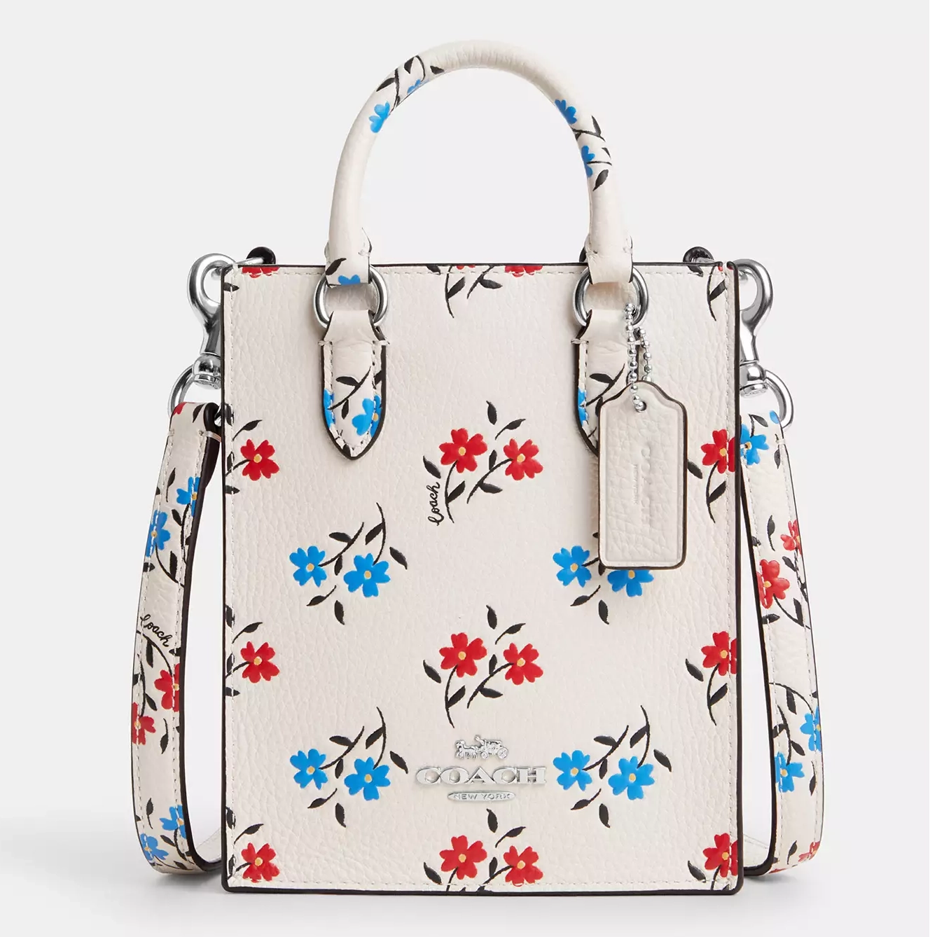White handbag with floral print and a brand logo tag attached to the handle.