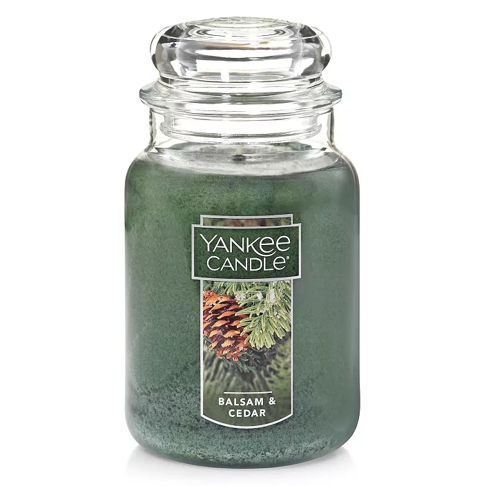 Yankee Candle Balsam & Cedar Large Jar features a deep green wax with a pine cone and evergreen label. The scent combines balsam, aromatic cedar wood, and juniper berry.