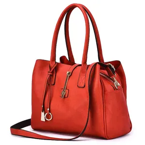A stylish red handbag with dual handles, a detachable shoulder strap, gold-tone hardware, and zipper detailing on the side.