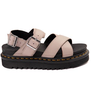 A platform sandal with a light pink double-strap design, silver buckles, and a thick black sole featuring yellow stitching detail.