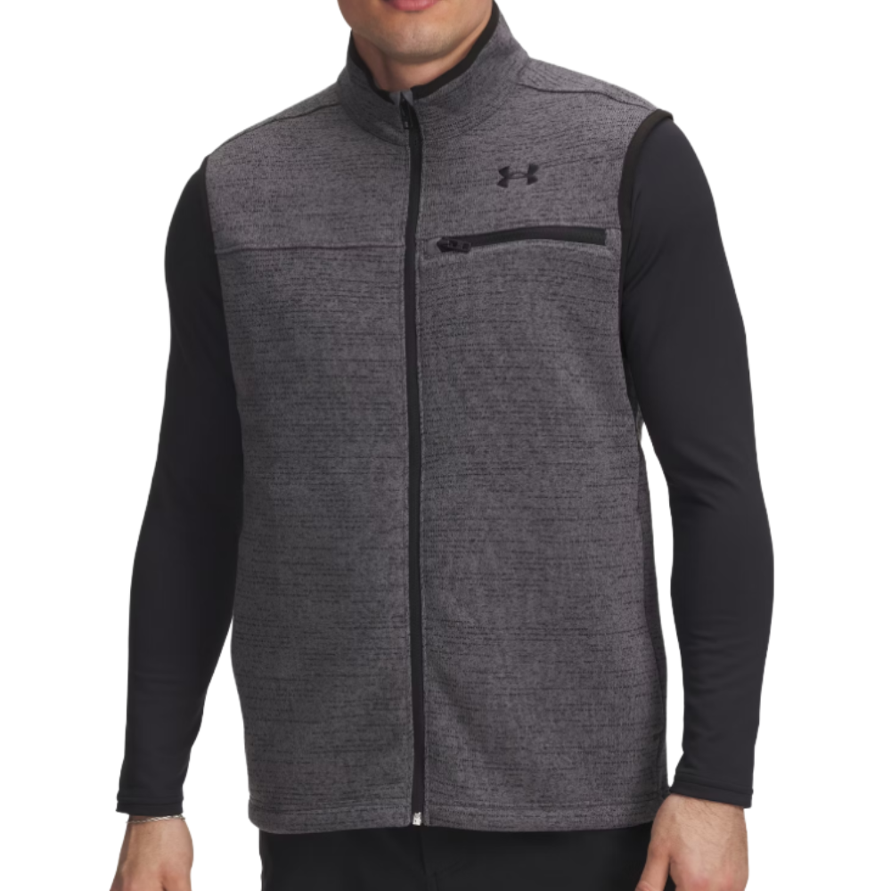 A man wearing a gray Under Armour zip-up vest with black trim and a chest pocket, over a black long-sleeve shirt.