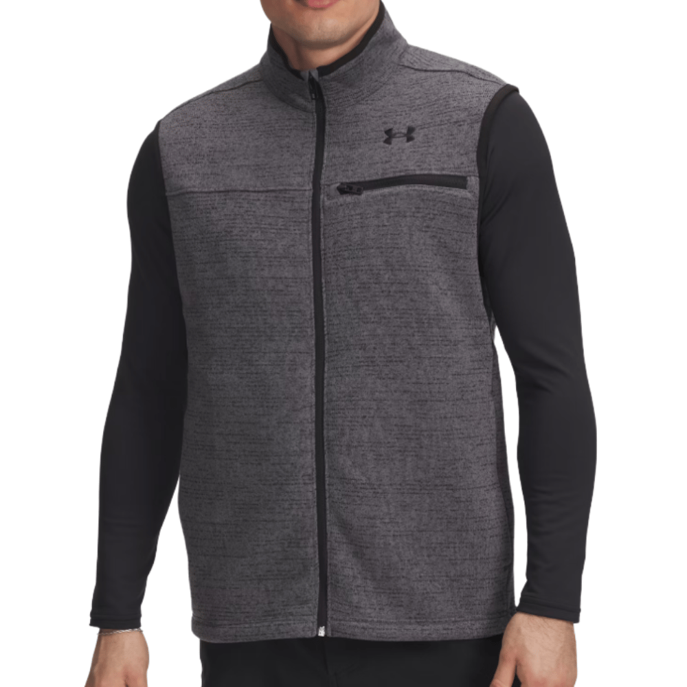 A man wearing a gray Under Armour zip-up vest with black trim and a chest pocket, over a black long-sleeve shirt.