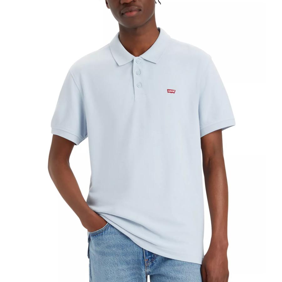 A person is wearing a light blue Levi's polo shirt with short sleeves and a small red logo on the chest, paired with blue jeans.
