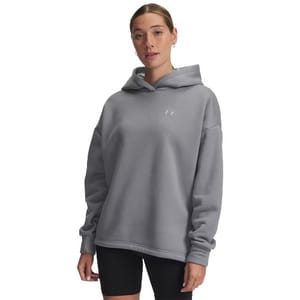 A woman is wearing a light grey hoodie with a small logo on the front, paired with black shorts.
