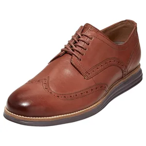 Brown leather wingtip oxford shoe with brogue detailing, featuring a lace-up design and cushioned sole.