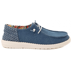 A casual denim slip-on shoe with white laces, featuring a textured heel and a multicolored interior lining, set on a white rubber sole.