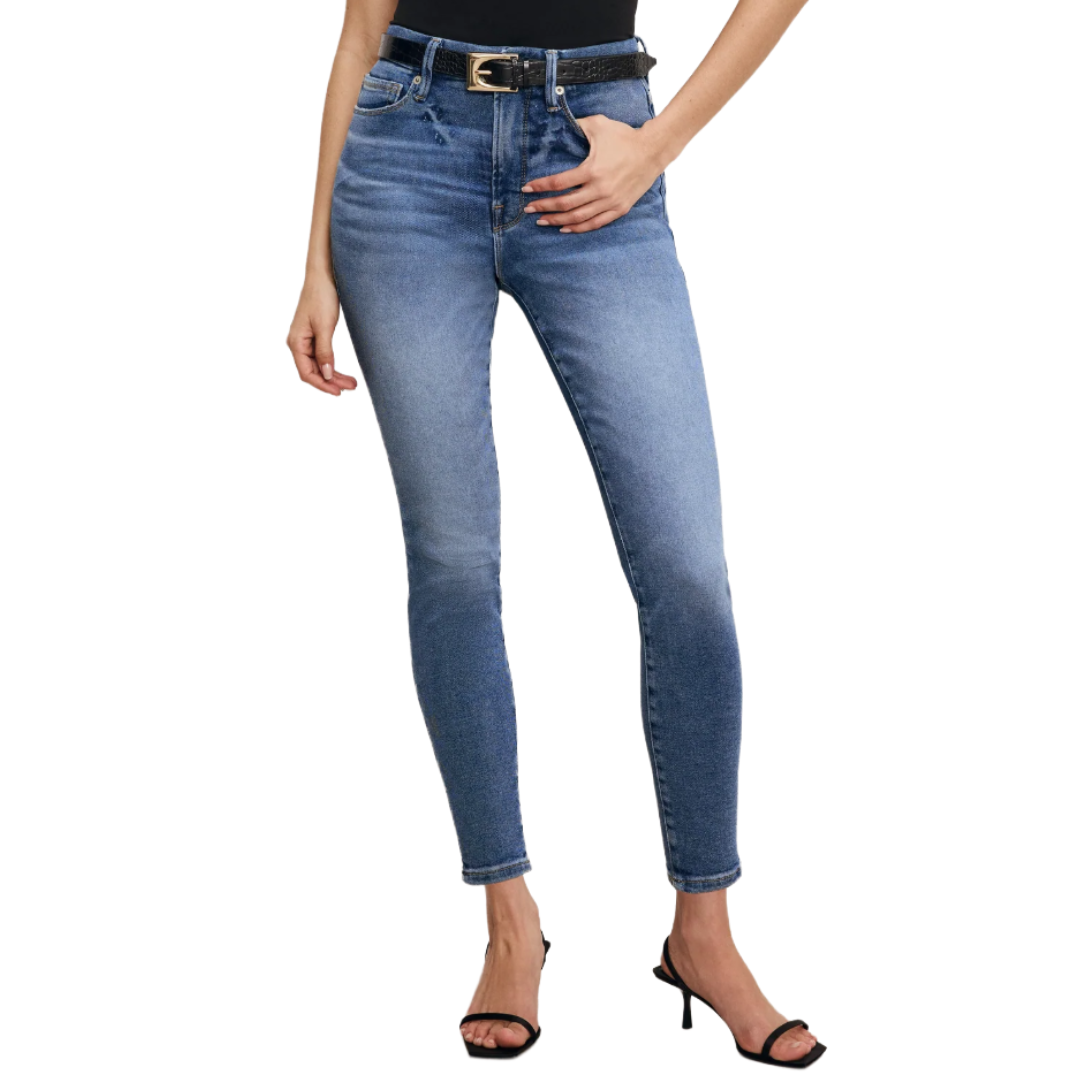 A person is wearing high-waisted, blue skinny jeans with a slight fade, a black belt, and black strappy high-heeled sandals.