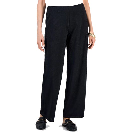 Black wide-leg pants with a subtle textured pattern, paired with black loafers and a gold bracelet.