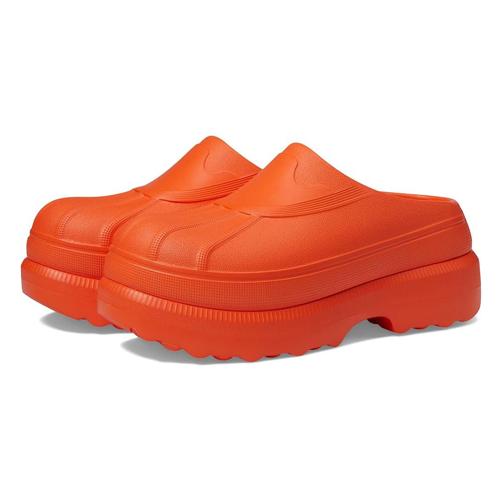 A pair of bright orange platform slides with a thick sole and no back or straps.