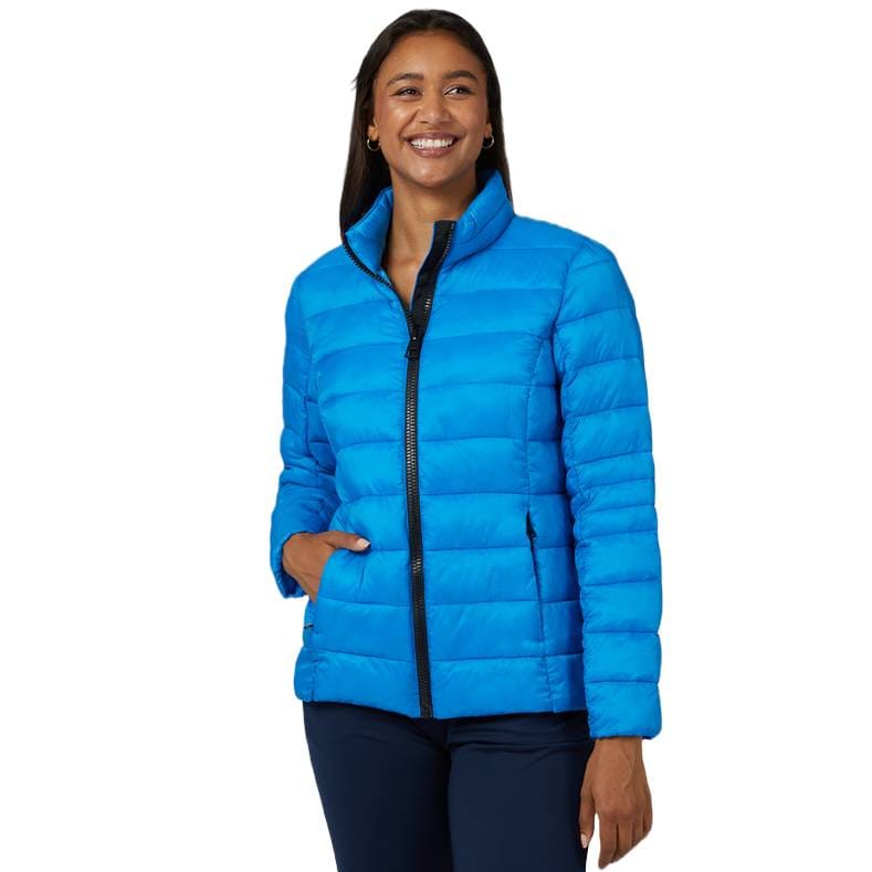 A woman is wearing a bright blue, quilted, zip-up puffer jacket. The jacket has a stand-up collar and side pockets, and it's designed to be lightweight and packable.