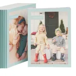 A stack of personalized photo books with light blue covers, each featuring different images of children on the front.