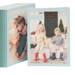 A stack of personalized photo books with light blue covers, each featuring different images of children on the front.
