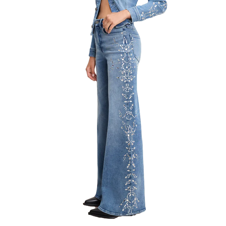 High-waisted blue denim jeans with flared legs, featuring intricate white floral embellishments along the sides. Paired with a matching cropped denim jacket.