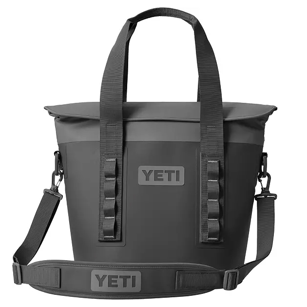 A black YETI soft cooler bag with handles and a detachable shoulder strap, featuring the YETI logo on both the bag and the strap.