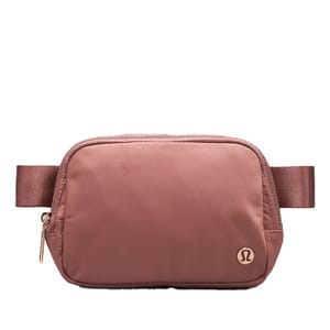 A small, brown belt bag with a simple design and metal zipper hardware, featuring a logo in the bottom right corner.