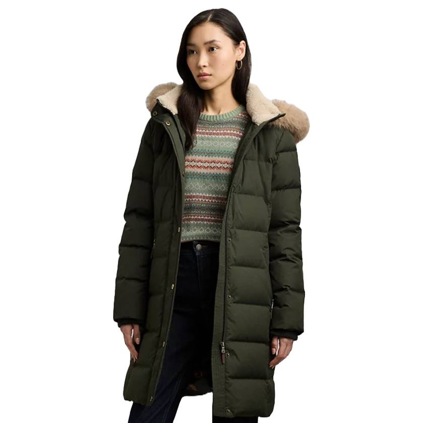 Ralph Lauren Hooded Puffer Coat in dark green with a long silhouette features a fur-lined hood and quilted design, providing warmth and style. The coat is paired with a patterned sweater and dark jeans, offering a casual yet chic look.